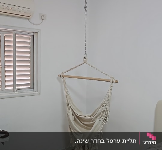 כיסא תלוי מחובר לתקרה בחדר עם מזגן
